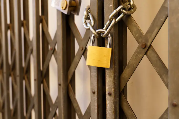 High-resolution image of a secure gate with a sturdy lock at the entrance of a self storage facility, symbolizing top-notch security and restricted access.
